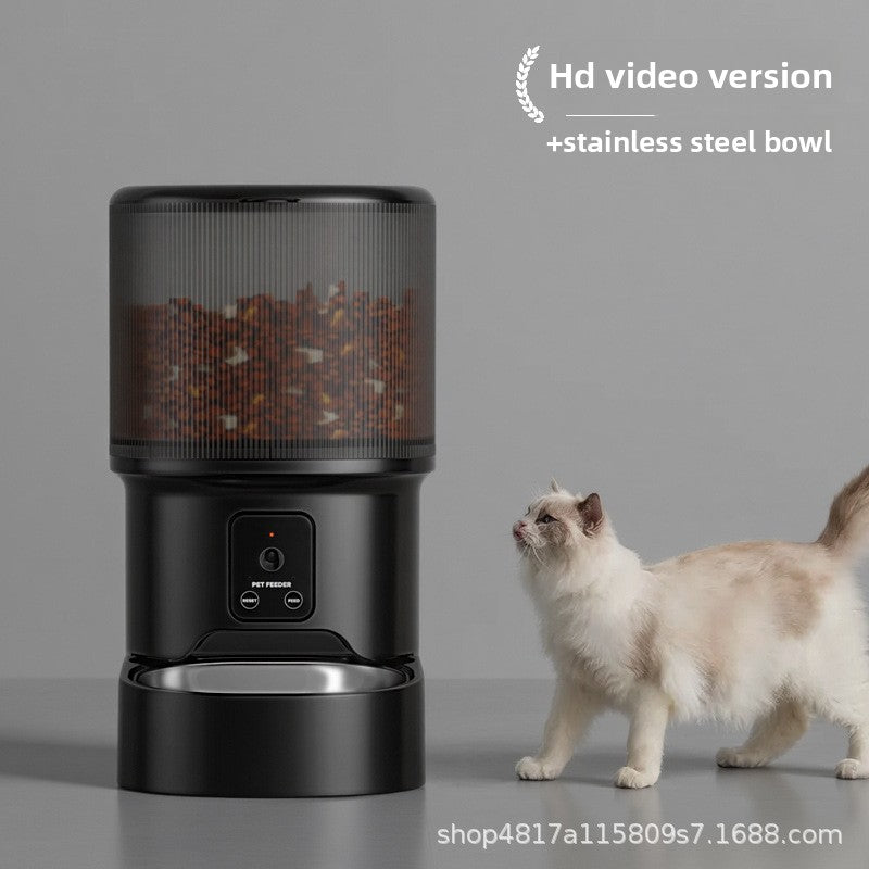 Black pet feeder with stainless steel bowl and a cat standing next to it on a gray background.